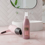 Visuel lifestyle dans une salle de bain mettant en avant le spray protecteur de chaleur à côté d'un sèche cheveux